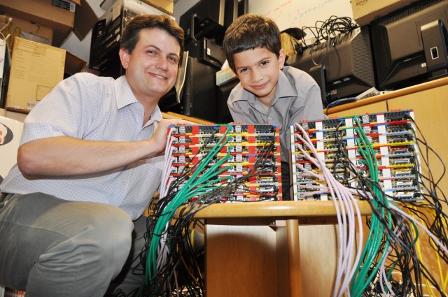 Professor Simon Cox of the University of Southhampton with his son and system racking consultant, James, show off their Raspberry Pi-based "supercomputer."