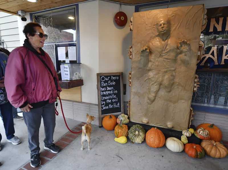 A customer and her dog enjoy a sculpture of "Star Wars" character Han Solo as he was frozen in carbonite made entirely of bread at the One House Bakery in Benicia, Calif. | Jose Carlos Fajardo/AP