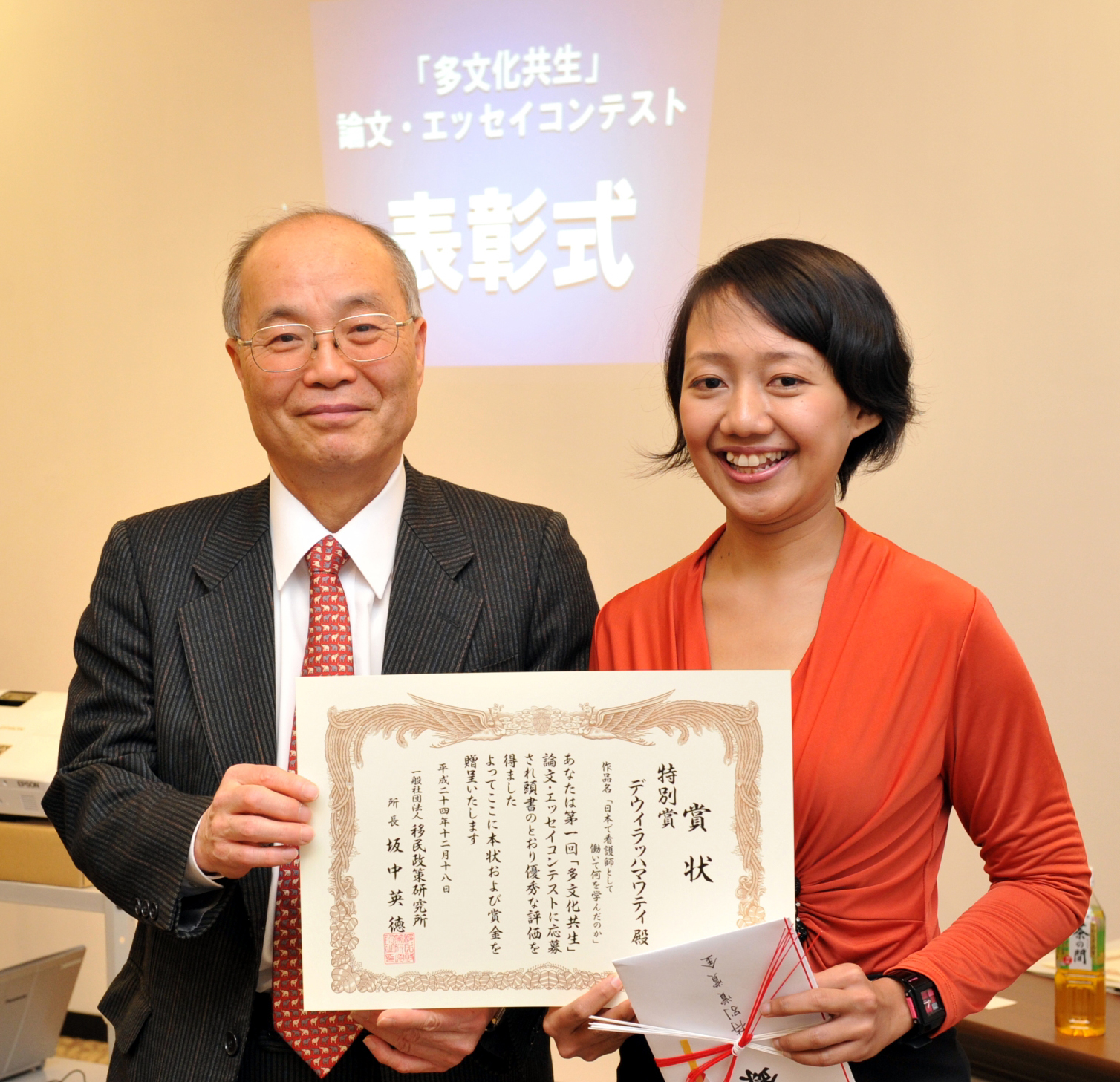 First steps: At an event in January 2013, former Tokyo Immigration Bureau chief Hidenori Sakanaka presents Indonesian Dewi Rachmawati with a prize for an essay she wrote about her struggle to become a nurse in Japan. | YOSHIAKI MIURA